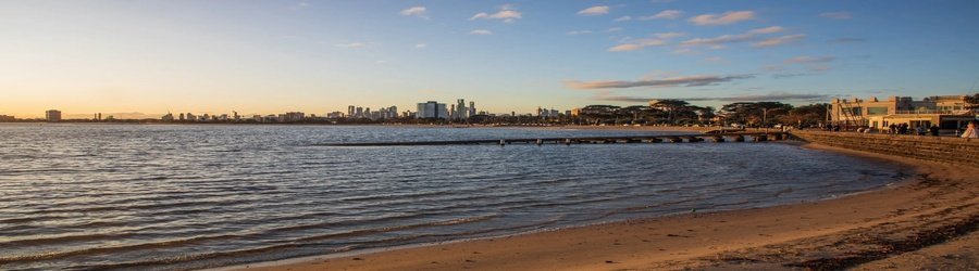 St Kilda Pier at sunset with city skyline views in Melbourne.