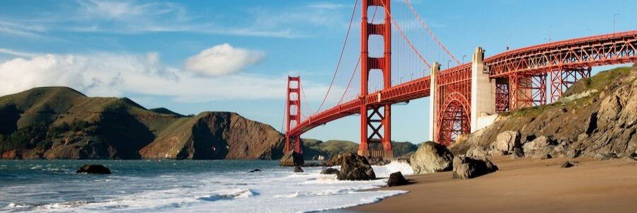 Baker Beach in San Francisco County with the Golden Gate Bridge, sandy shoreline, ocean waves, and coastal cliffs in the background