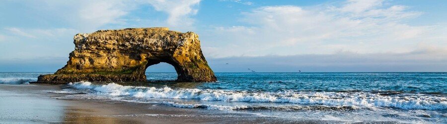 Natural Bridges State Beach rock arch at sunset in Northern California.