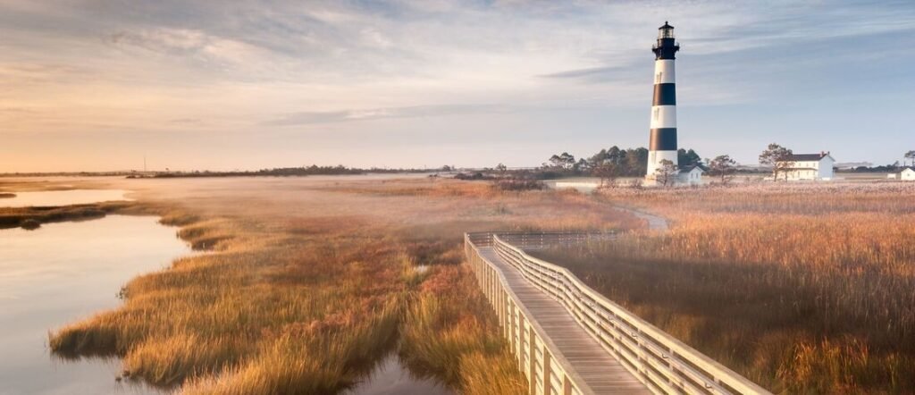 Cape Hatteras Lighthouse, North Carolina | Beach Travel Destinations Cape Hatteras Lighthouse overlooking the marshes and coastline of North Carolina's Outer Banks.