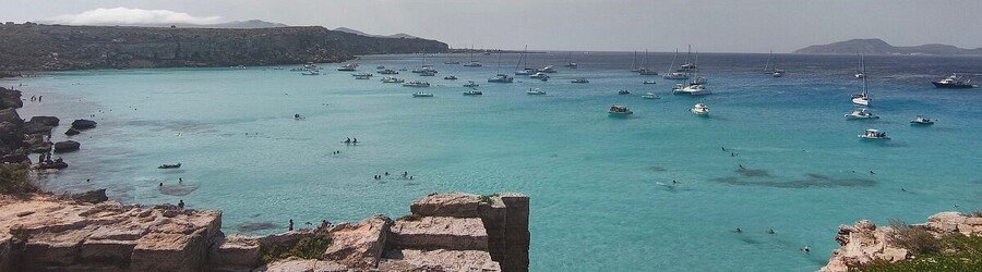 Cala Rossa beach in Favignana with turquoise water and boats in the bay