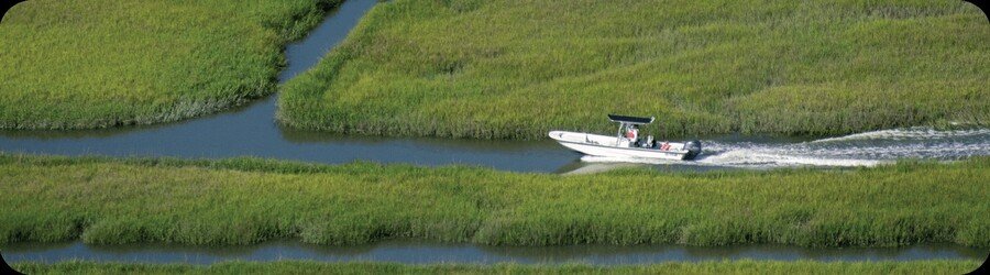 A small boat glides through winding coastal marshes in Georgia.