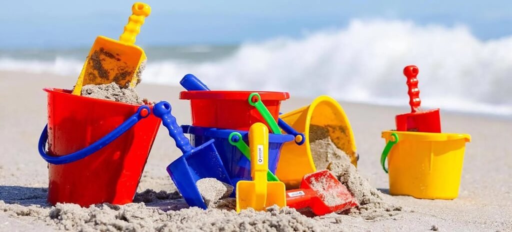 Colorful beach toys in the sand with buckets and shovels – the best beach toys kids will surprisingly love.