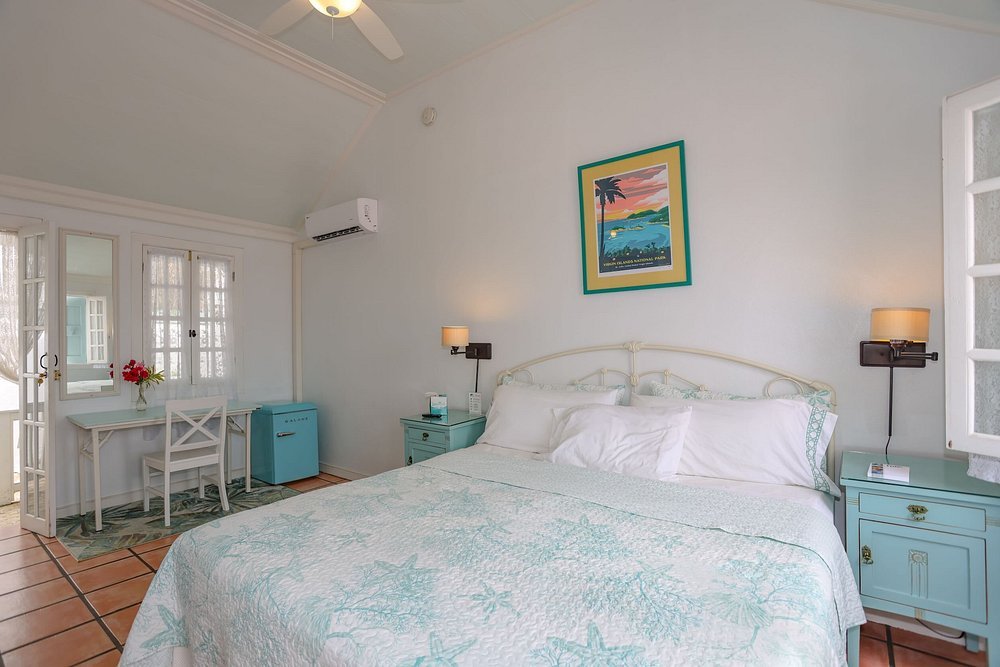 Charming guestroom at At Home in The Tropics Inn in St thomas with pastel decor, desk, and vintage touches