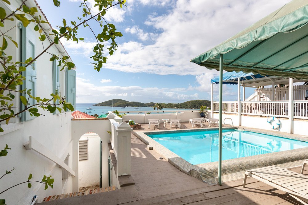 Small pool terrace at At Home in The Tropics Inn in St thomas with ocean views and shaded seating