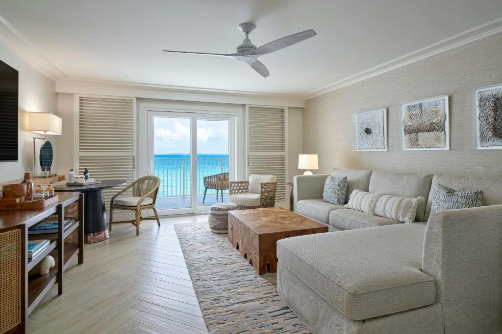 Open living area at Buoy Haus Beach Resort in St thomas with sofa, balcony ocean view, and coastal decor