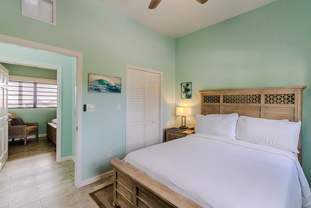 Coastal-style bedroom at Point Pleasant Resort in St thomas with soft blue walls and wooden furnishings