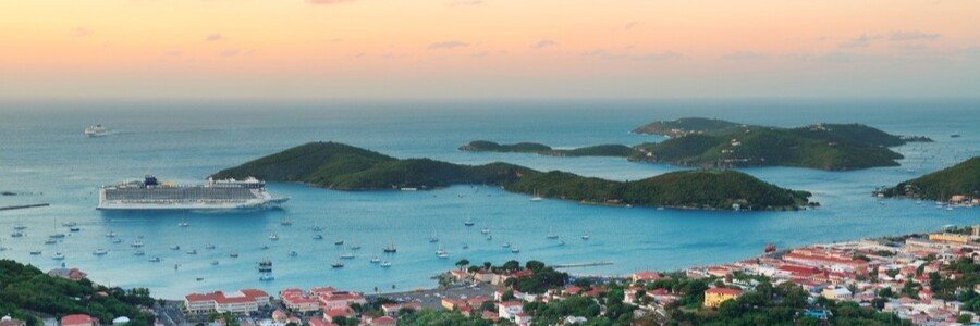 Aerial view of St thomas harbor with cruise ship, sailboats, and surrounding green islands at sunset