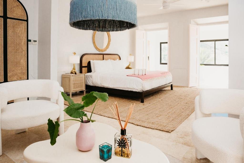 Bright boutique guestroom at The Pink Palm Hotel in St thomas with neutral decor, woven textures, and spacious layout