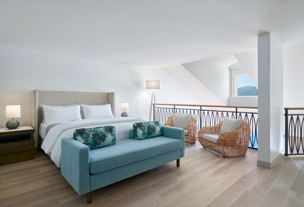 Bright modern guestroom at The Westin St thomas with coastal decor, bed, seating area, and natural light