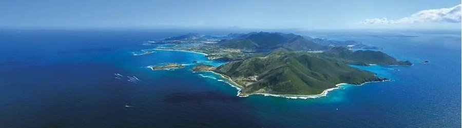 Aerial view of St Martin island coastline with turquoise Caribbean water and lush green hills