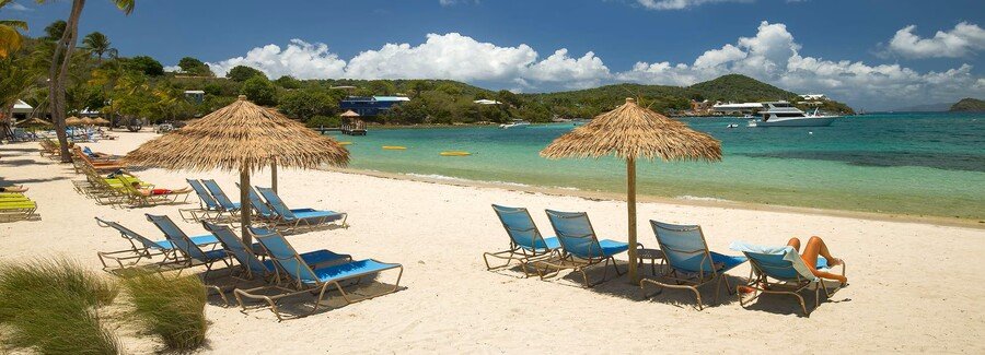 St thomas beach with lounge chairs, thatched umbrellas, white sand, and calm turquoise water