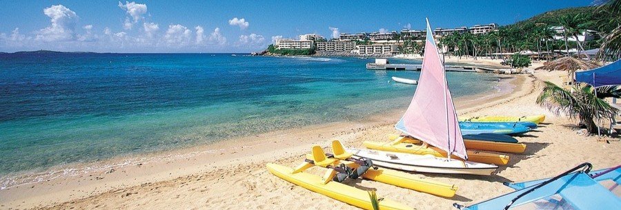 Sapphire Beach in St thomas with colorful sailboats, kayaks on the sand, and clear turquoise water