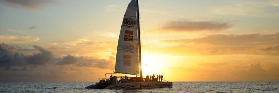 Catamaran sailing across the Caribbean Sea at sunset in St. Martin.