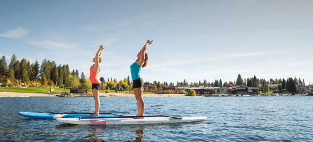 Best stand-up paddleboarding guide – women practicing yoga on SUP boards at a calm lake