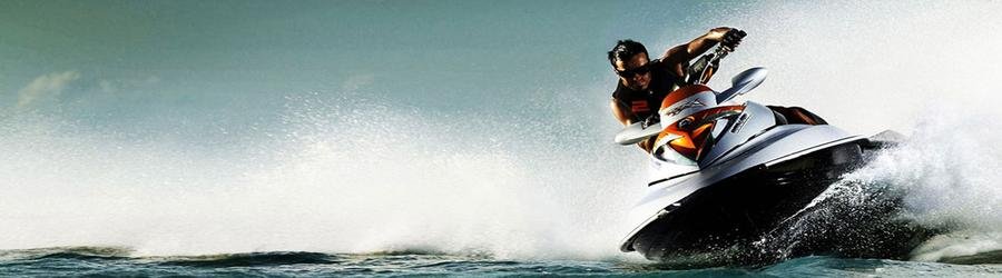 Man riding a powerful jet ski and carving across the waves at high speed.