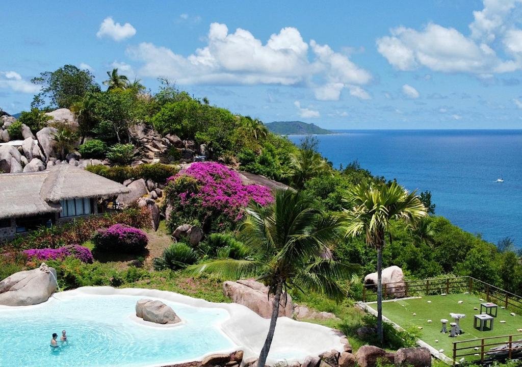 Oceanfront pool and tropical hillside at Chateau de Feuilles Praslin Island