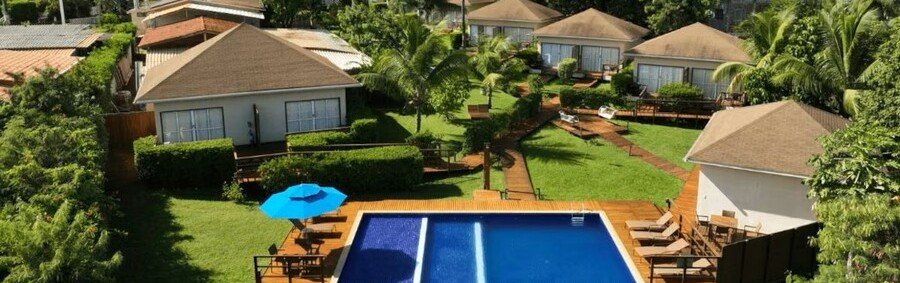 Swimming Pool and Bungalows at Pousada Lua Bela | Beach Travel Destinations High-angle aerial view of the swimming pool, sun loungers, and private guest bungalows at Pousada Lua Bela in Fernando de Noronha, Brazil.