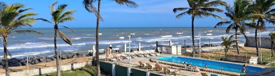 Beachfront Swimming Pool at Pousada Mirante | Beach Travel Destinations Elevated beachfront view of the outdoor swimming pool and sun loungers at Pousada Mirante in Conceição da Barra, Brazil.