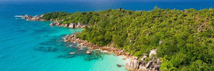 Aerial view of tropical coastline with turquoise water and lush greenery Praslin Island Seychelles