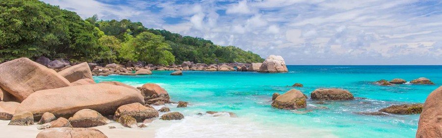 Granite rocks and turquoise water along tropical beach Praslin Island Seychelles