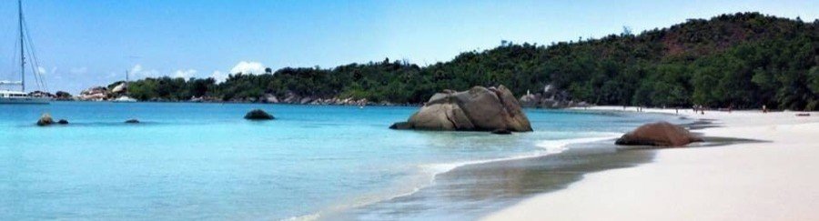 White sand beach with granite boulders and calm water Praslin Island Seychelles