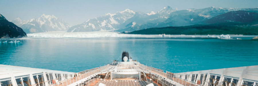 View from Alaska cruise ship deck approaching glacier with mountains and icy water