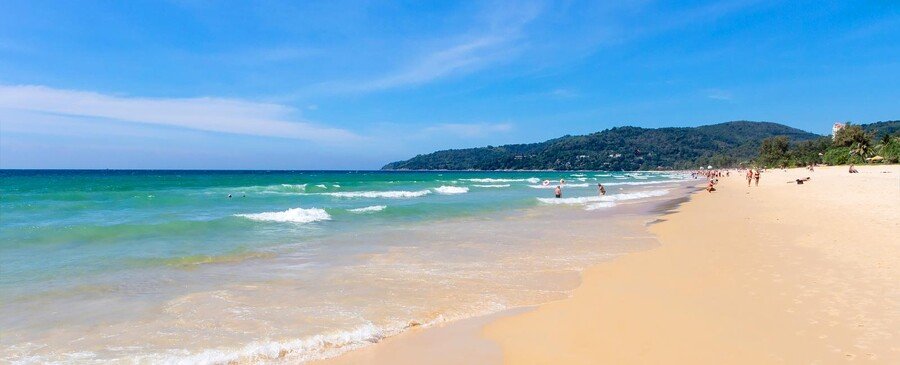Karon Beach Phuket Thailand with sandy shoreline, turquoise waves, and scenic tropical coastline
