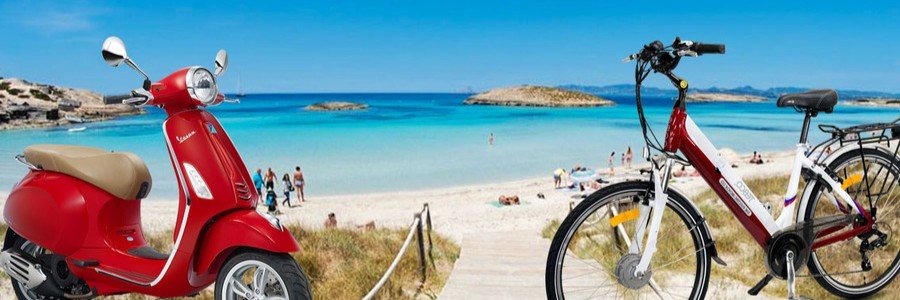 A red Vespa scooter and a white electric bicycle parked near a wooden path leading to Ses Illetes beach in Formentera.