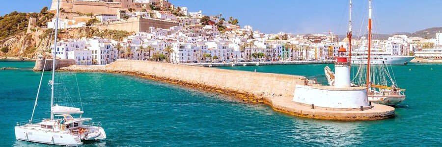 Day tour boat arriving from Formentera at the Port of Ibiza with Dalt Vila old town in the background.