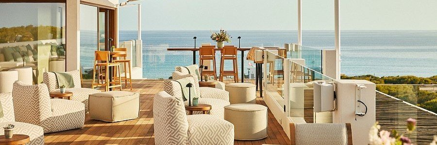 Luxury rooftop terrace lounge with patterned armchairs and bar stools at Teranka Formentera overlooking the Mediterranean Sea.