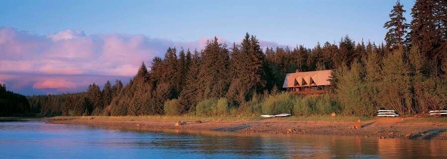 Glacier Bay Lodge waterfront view in Yakutat Alaska with forest shoreline and calm coastal water