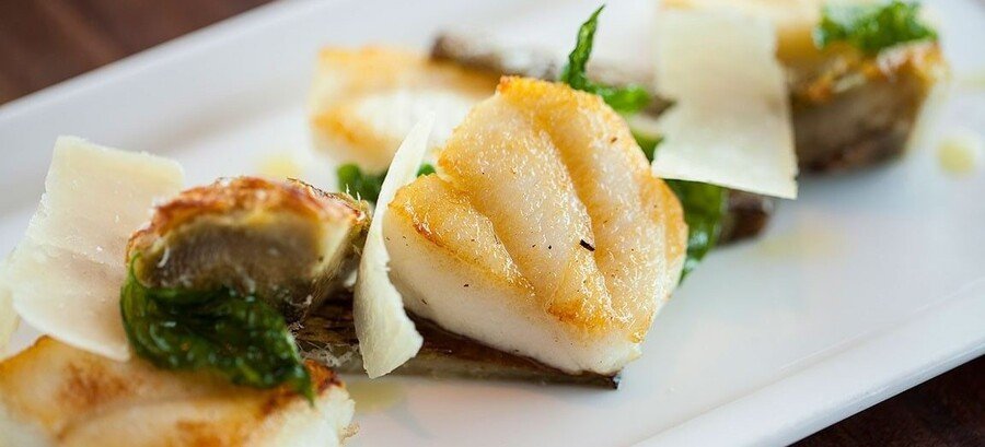 Seared halibut cheeks served with greens and shaved cheese in Yakutat Alaska