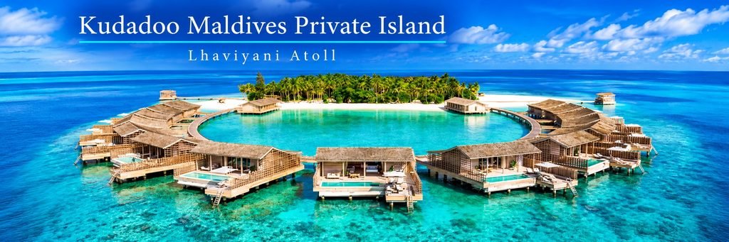 Aerial view of luxurious overwater villas arranged around a turquoise lagoon, with private infinity pools, wooden walkways, and a lush tropical island in the Maldives.