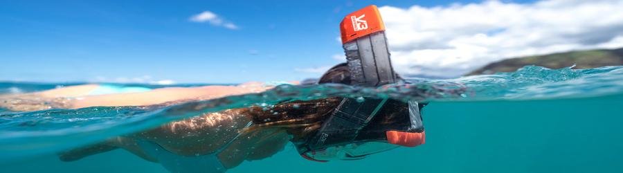 Snorkeler floating calmly on the ocean surface with snorkel tube visible above water.