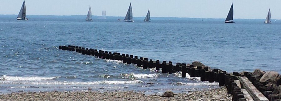 Burying Hill Beach Westport Connecticut rocky shoreline with sailboats on Long Island Sound