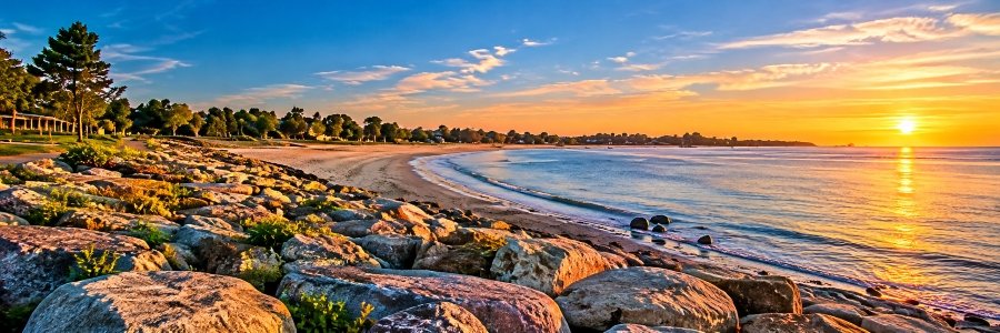 Sunset view inspired by Sherwood Island State Park, one of the scenic Westport Beaches in Connecticut, featuring a curved sandy shoreline, coastal rocks, and Long Island Sound.
