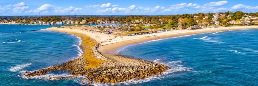 Aerial view of Westport Beaches in Connecticut, featuring sandy shores, blue waters of Long Island Sound, and a scenic coastline.