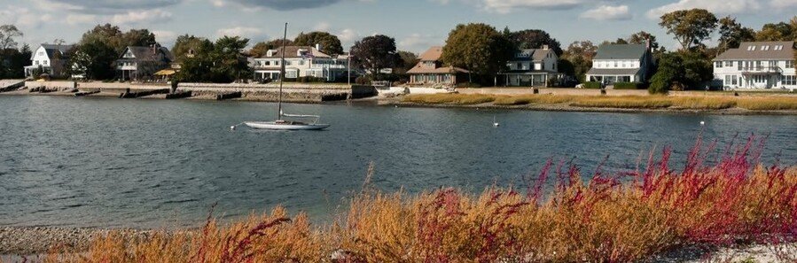 Westport Connecticut waterfront homes along Long Island Sound with sailboat and coastal shoreline