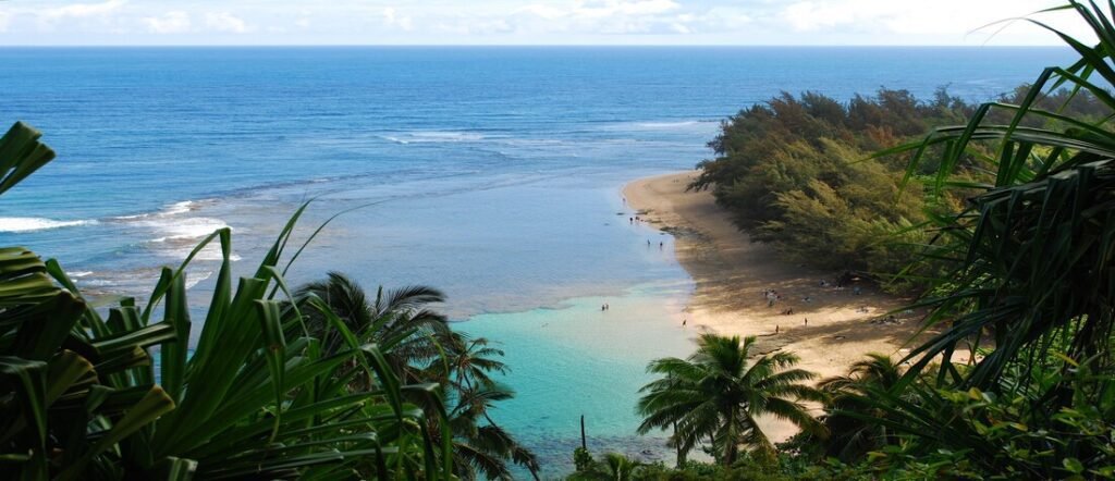 Hanalei Bay with turquoise water, a wooden pier, and lush mountain backdrop on Kauai.
