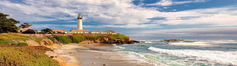 Pigeon Point Lighthouse overlooking the rocky San Mateo coastline with waves rolling onto the beach.