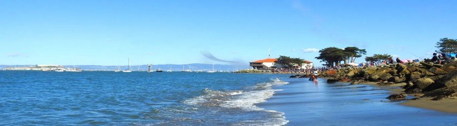 View of San Francisco Bay with boats sailing near Alcatraz Island on a clear blue day.