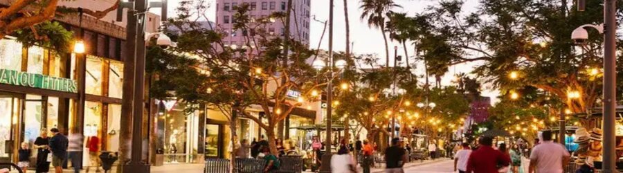 Third Street Promenade in Santa Monica lit up at dusk with shoppers and cafés.