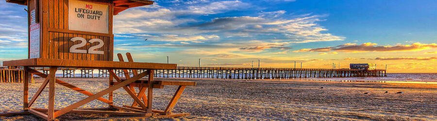 Sunset over a Santa Monica lifeguard tower and wide sandy beach.
