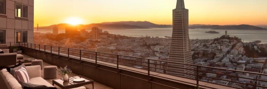 Terrace view from Four Seasons Hotel overlooking downtown San Francisco, the bay, and Transamerica Pyramid at sunset.
