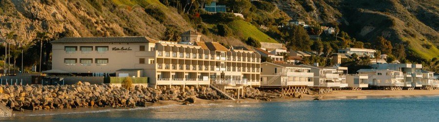 Exterior coastal view of Malibu Beach Inn built directly over the rocks on Carbon Beach