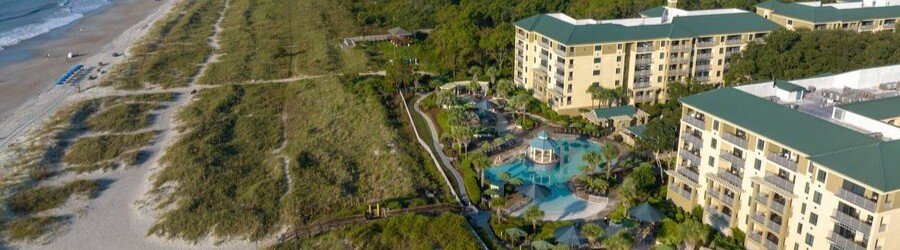 Aerial view of the oceanfront pool deck and green-roofed buildings at Marriott's Barony Beach Club