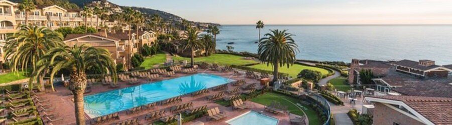 Scenic coastal pool deck with palm trees overlooking the Pacific Ocean cliffside at Montage Laguna Beach