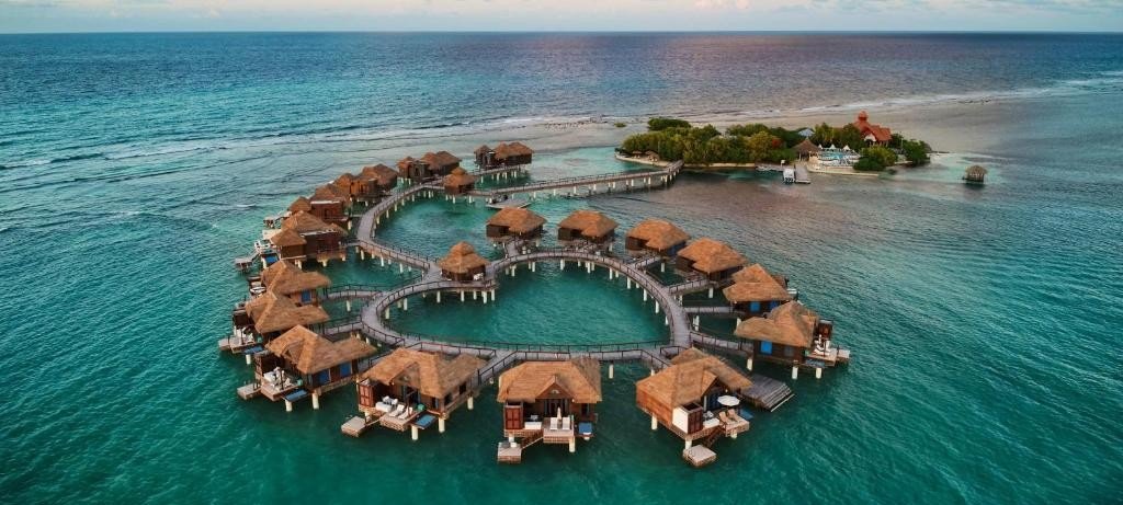 Overwater bungalows at Sandals Royal Caribbean resort with turquoise ocean and private island view.  Choose the best Sandals Resorts for you!