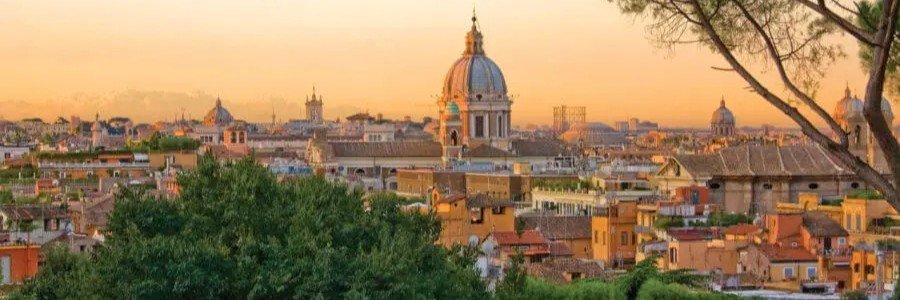 View of Rome skyline from Janiculum Hill with domes, trees, and sunset light